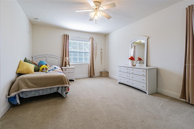 bedroom featuring a textured ceiling, ceiling fan, and light carpet