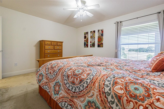 carpeted bedroom featuring ceiling fan and a textured ceiling