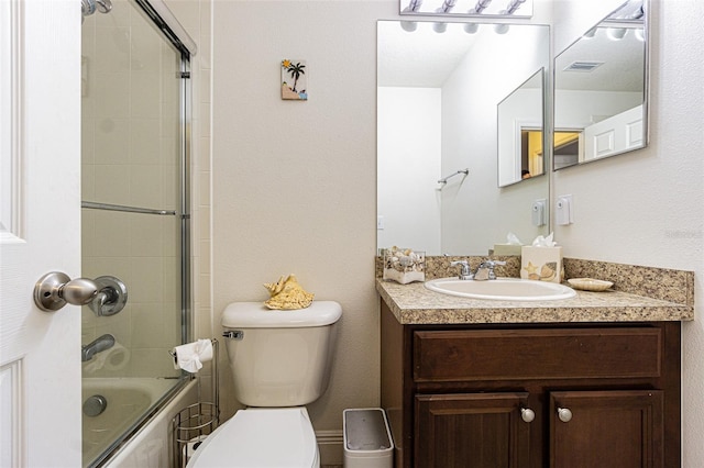 full bathroom with vanity, toilet, and bath / shower combo with glass door