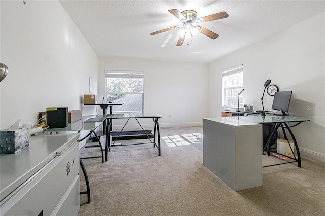 home office with a textured ceiling, light colored carpet, ceiling fan, and a healthy amount of sunlight