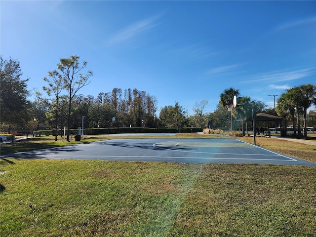 view of sport court with a lawn