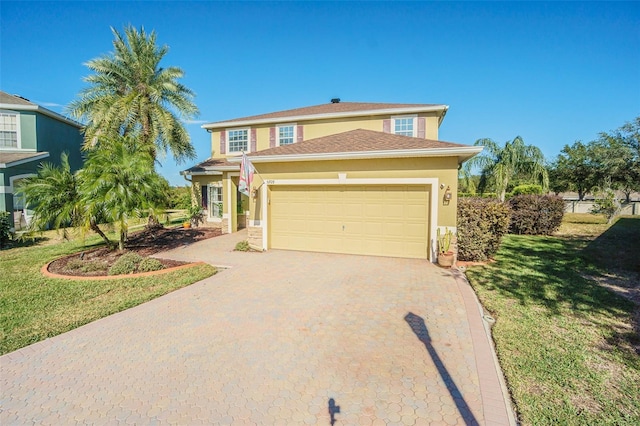 5709 White Trillium Loop, Land O Lakes, FL 34639 - traditional home with decorative driveway, an attached garage, stucco siding, and a front lawn