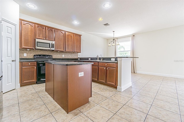 5709 White Trillium Loop, Land O Lakes, FL 34639 - kitchen with stainless steel microwave, black range with electric cooktop, a peninsula, a kitchen island, and light tile patterned floors