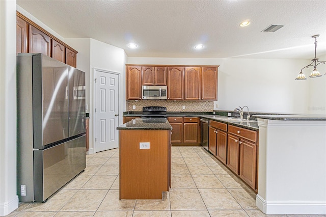 5709 White Trillium Loop, Land O Lakes, FL 34639 - kitchen with appliances with stainless steel finishes, a kitchen island, dark stone countertops, backsplash, and a peninsula