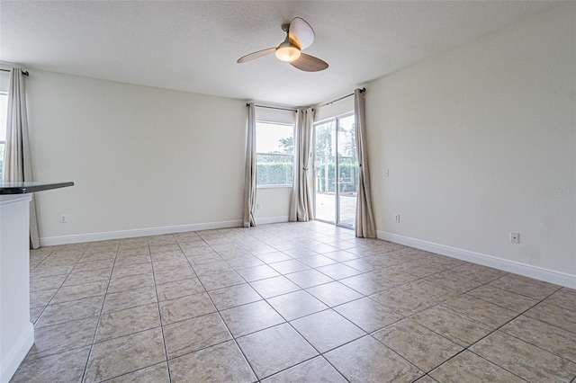 5709 White Trillium Loop, Land O Lakes, FL 34639 - tiled empty room featuring a ceiling fan, a textured ceiling, and baseboards