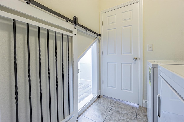 5709 White Trillium Loop, Land O Lakes, FL 34639 - washroom with light tile patterned floors, washing machine and clothes dryer, and a barn door