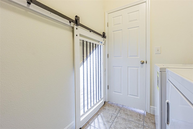 5709 White Trillium Loop, Land O Lakes, FL 34639 - clothes washing area featuring washer and dryer, light tile patterned flooring, and a barn door