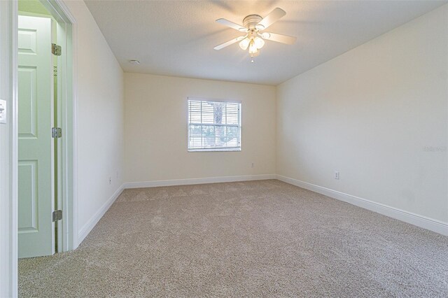 5709 White Trillium Loop, Land O Lakes, FL 34639 - unfurnished room with light colored carpet, a ceiling fan, and baseboards