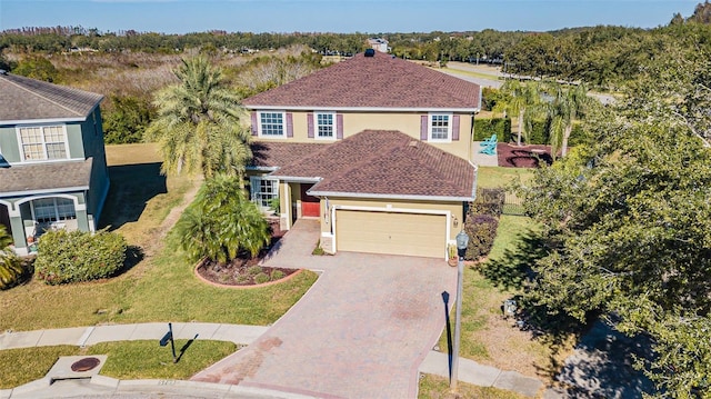 5709 White Trillium Loop, Land O Lakes, FL 34639 - traditional-style house with a garage, decorative driveway, a front yard, and stucco siding