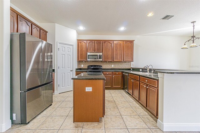 5709 White Trillium Loop, Land O Lakes, FL 34639 - kitchen with appliances with stainless steel finishes, a center island, dark stone countertops, a sink, and backsplash