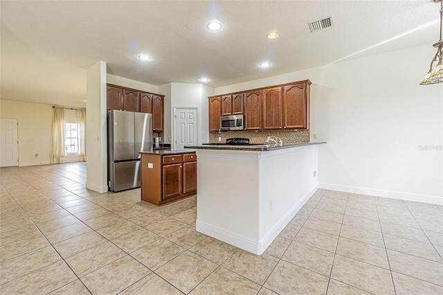 5709 White Trillium Loop, Land O Lakes, FL 34639 - kitchen with stainless steel appliances, dark countertops, light tile patterned flooring, decorative backsplash, and recessed lighting