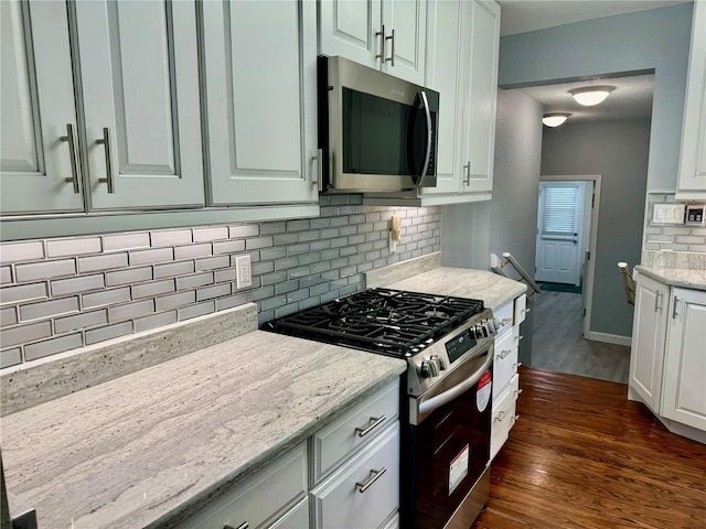1003 Beverly Ave, Largo, FL 33770 - kitchen featuring appliances with stainless steel finishes, dark wood-style floors, backsplash, and white cabinetry