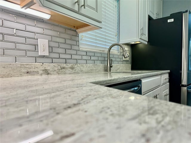 1003 Beverly Ave, Largo, FL 33770 - kitchen featuring backsplash, a sink, freestanding refrigerator, and light stone countertops