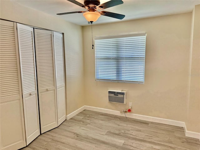 1003 Beverly Ave, Largo, FL 33770 - unfurnished bedroom featuring a wall mounted air conditioner, light wood finished floors, a closet, baseboards, and ceiling fan