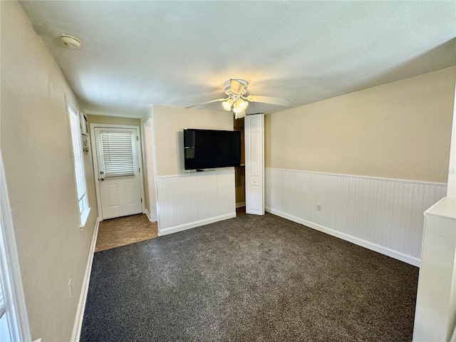 1003 Beverly Ave, Largo, FL 33770 - spare room with dark colored carpet, ceiling fan, a smoke detector, and a wainscoted wall