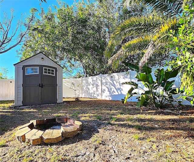 view of yard featuring a shed and an outdoor fire pit