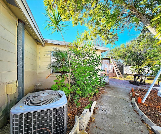 view of home's exterior with central air condition unit and a storage shed