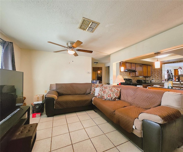 tiled living room featuring a textured ceiling and ceiling fan