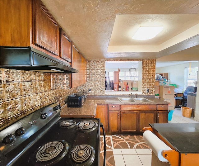 kitchen featuring decorative backsplash, range with electric cooktop, extractor fan, sink, and light tile patterned floors