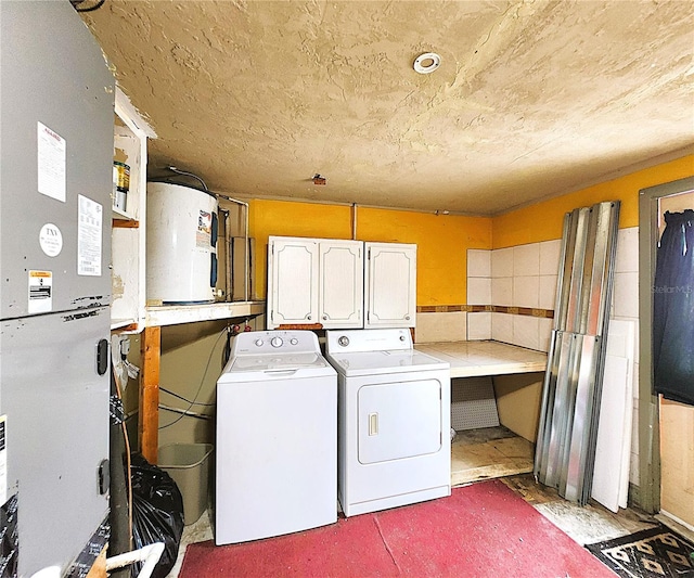 clothes washing area featuring cabinets, washing machine and dryer, and electric water heater