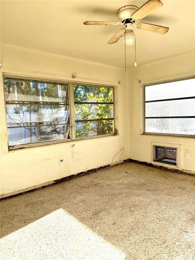 unfurnished room with ceiling fan and plenty of natural light