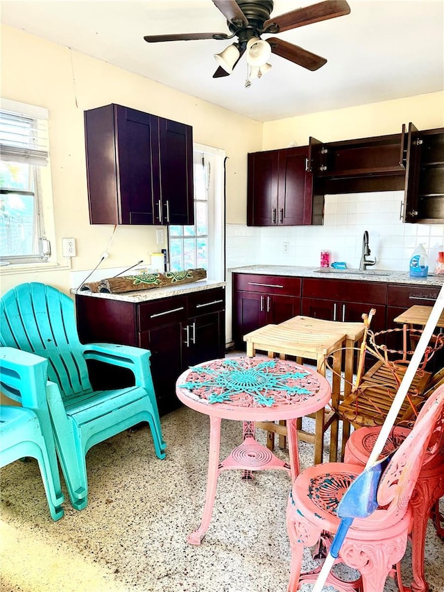 kitchen featuring backsplash, ceiling fan, and sink