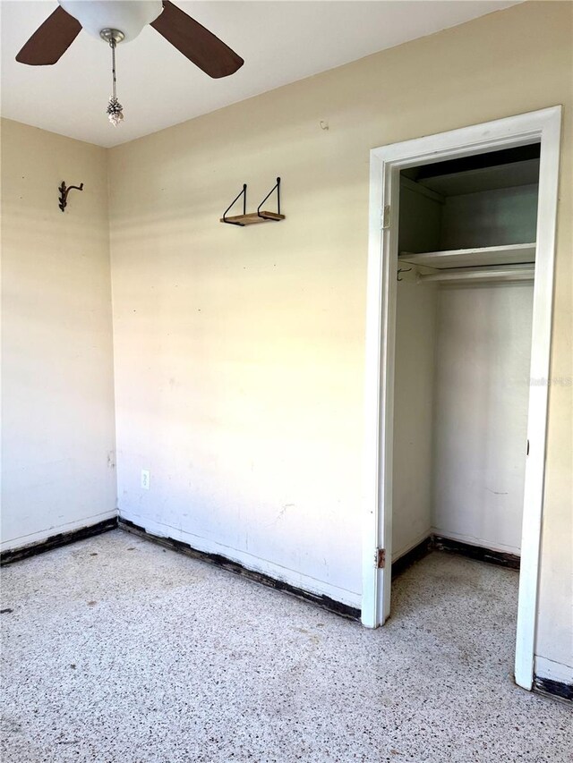 interior space featuring ceiling fan and a closet