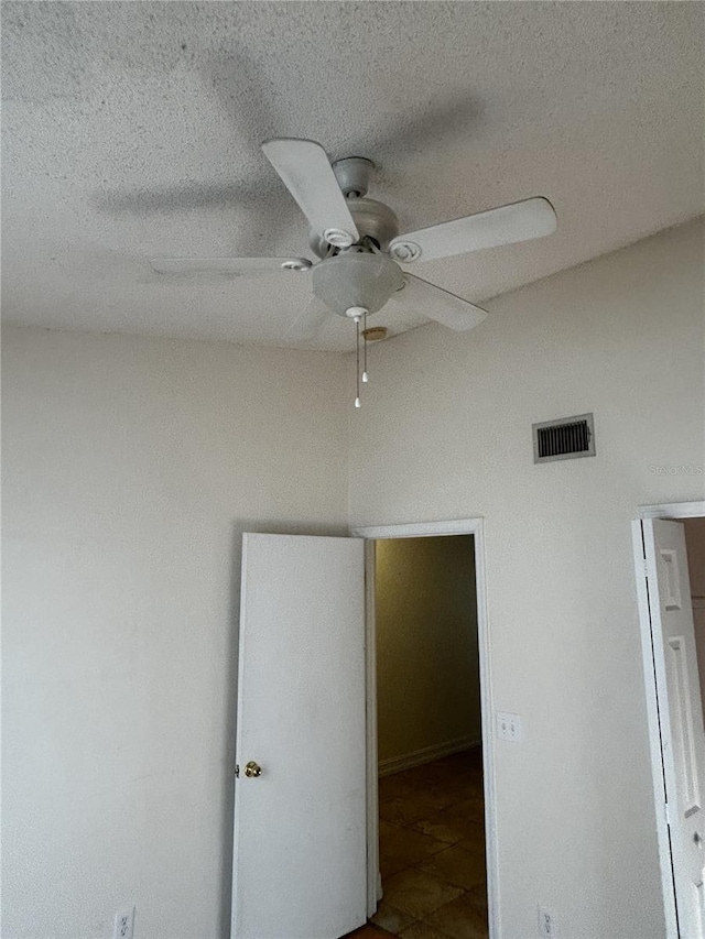 unfurnished bedroom featuring ceiling fan and a textured ceiling