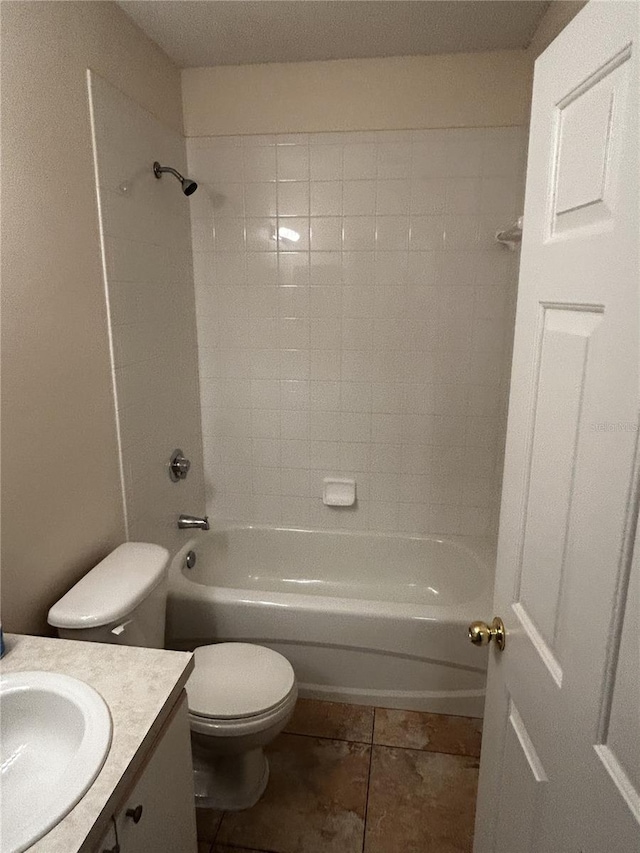 full bathroom featuring tiled shower / bath, tile patterned flooring, vanity, and toilet