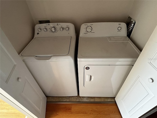 laundry room featuring washing machine and dryer and hardwood / wood-style flooring