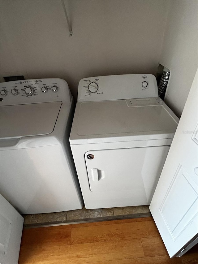 washroom with washer and dryer and wood-type flooring