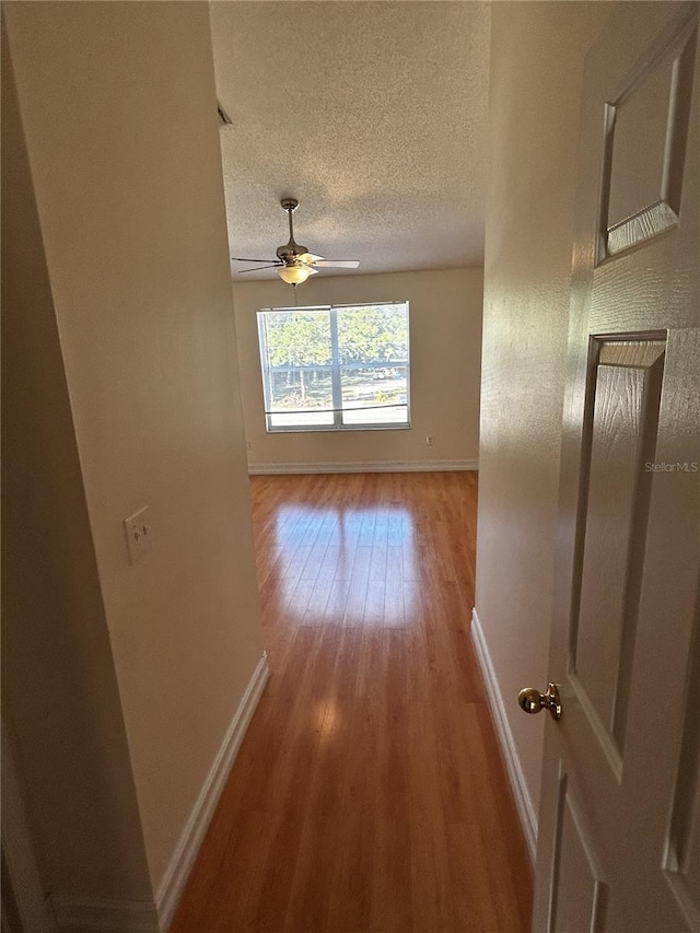 hallway featuring hardwood / wood-style flooring and a textured ceiling