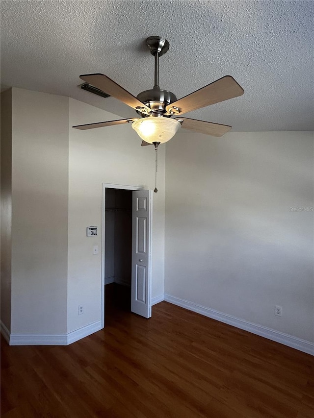 spare room featuring ceiling fan, dark hardwood / wood-style flooring, and a textured ceiling