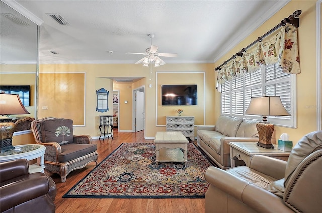 living room featuring light wood-type flooring, ceiling fan, and crown molding