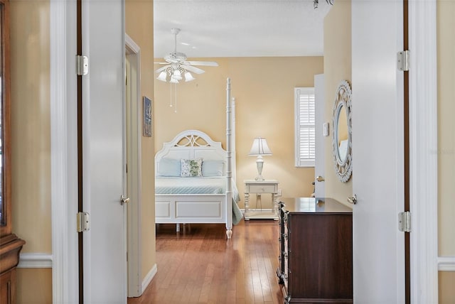 bedroom with ceiling fan, dark hardwood / wood-style flooring, and a textured ceiling