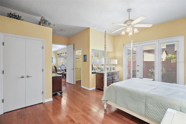 bedroom with multiple windows, hardwood / wood-style floors, a textured ceiling, and ceiling fan