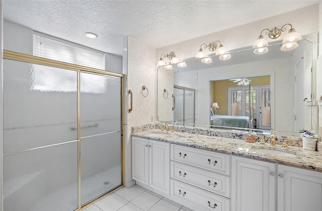 bathroom featuring ceiling fan, walk in shower, tile patterned floors, a textured ceiling, and vanity