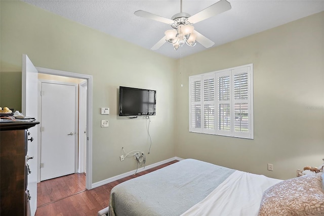 bedroom featuring hardwood / wood-style flooring, ceiling fan, and a textured ceiling