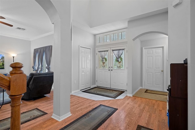 foyer featuring ceiling fan, french doors, crown molding, and light hardwood / wood-style flooring