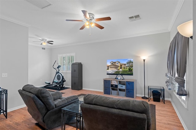 living room featuring ceiling fan, crown molding, and light hardwood / wood-style flooring