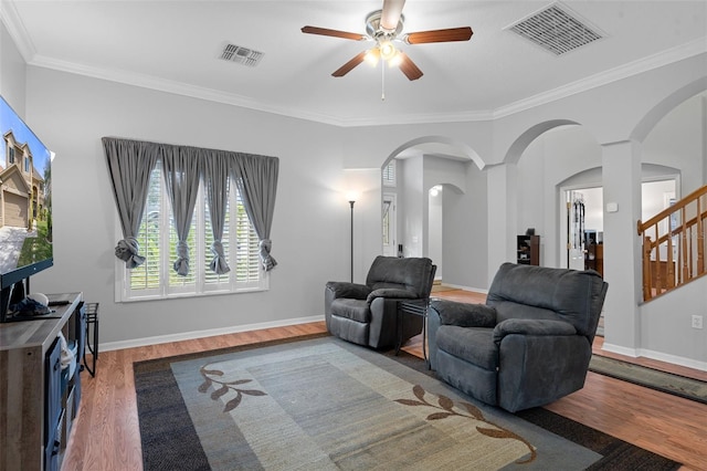 living room featuring ceiling fan, wood-type flooring, and crown molding