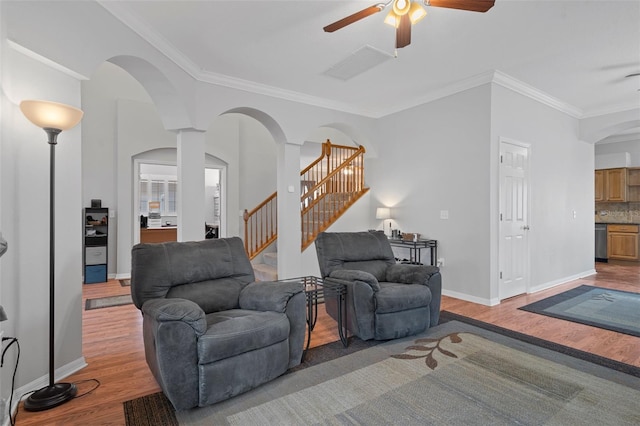 living room featuring crown molding, light hardwood / wood-style flooring, and ceiling fan