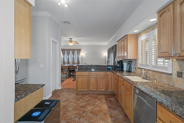 kitchen with kitchen peninsula, stainless steel dishwasher, dark stone countertops, and sink