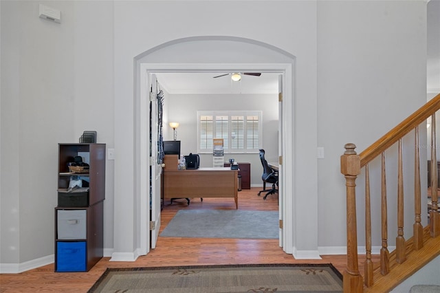 corridor with hardwood / wood-style floors and ornamental molding