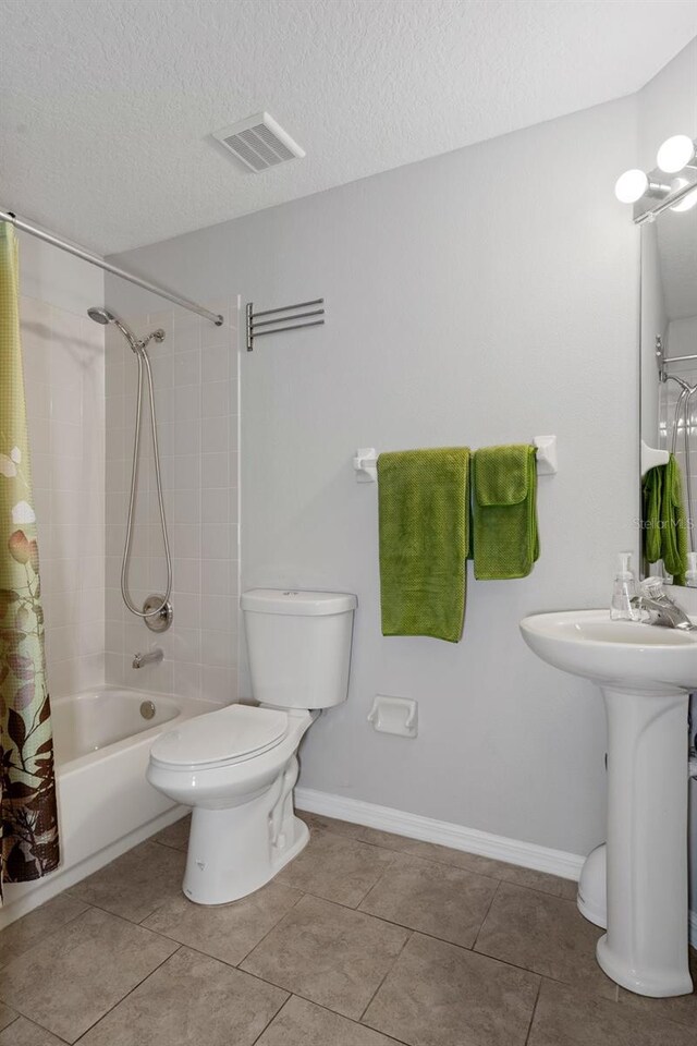 bathroom featuring toilet, a textured ceiling, tile patterned floors, and shower / bathtub combination with curtain