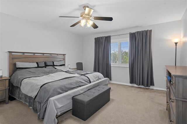 bedroom featuring light colored carpet and ceiling fan