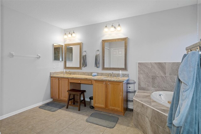 bathroom with tile patterned floors, tiled bath, and vanity