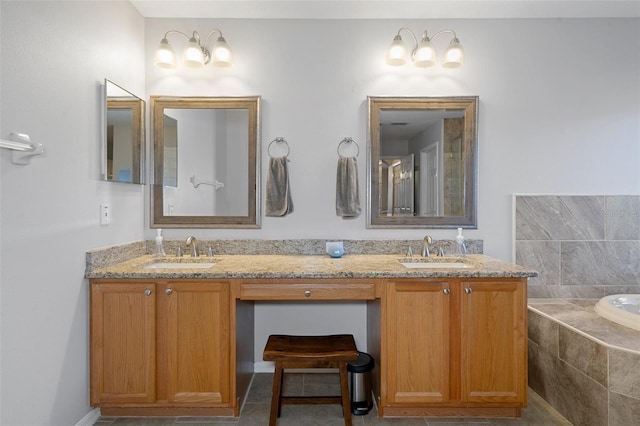 bathroom featuring tile patterned flooring, vanity, and tiled tub