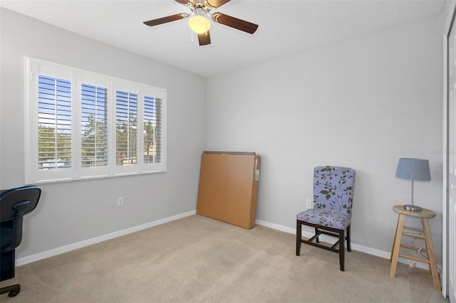 living area featuring light carpet and ceiling fan