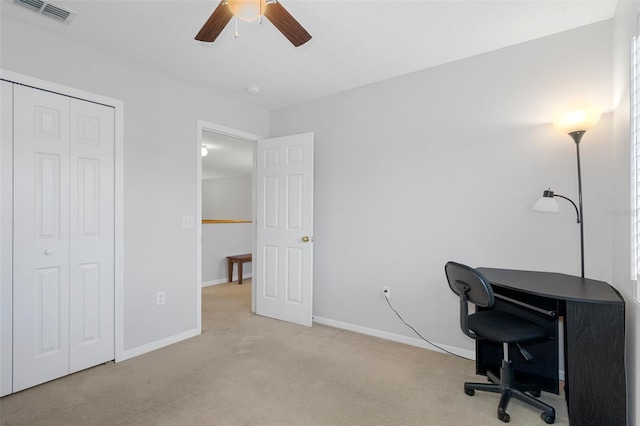 carpeted office space with ceiling fan